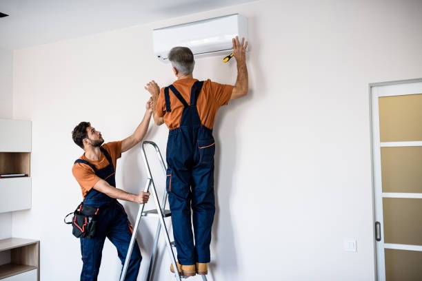 imgi_11_two-workers-in-uniform-air-conditioning-masters-using-ladder-while-installing-a-new-air